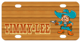 Name on left in shadowed text with cowboy with big rimmed cowboy hat holding pointed guns in both hands on right. Wood tone background and cowboy is dressed in blueish teal and rusty orange