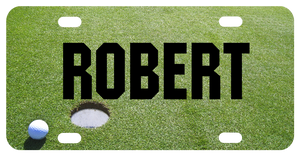 Personalized vanity license plate with golf ball next to hole on green custom printed with any name