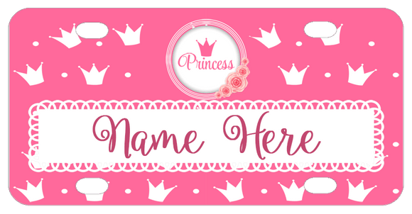 Pink Background with white crowns scattered on the plate Circle on top has a rose cluster on bottom and a pink crown and word princess. Your name is personalized in a white border towards the bottom of the plate