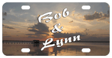 Sun setting through the clouds on the lake with a pier and boat. Any text personalized.